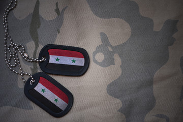 army blank, dog tag with flag of syria on the khaki texture background. military concept