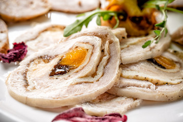 Sliced pieces of meat rolls on white plate. Close up with selective focus