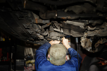 Obraz na płótnie Canvas Repairmen Under Car
