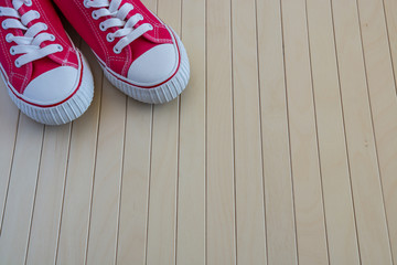 Red new sneakers on the wooden background