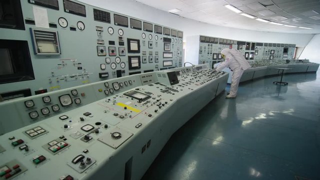  Astronaut alone in mission control room, pressing switches on control panel
