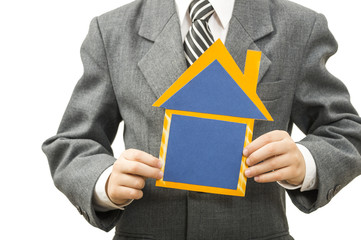 boy holding a cardboard house in hands on his head construction helmet, he himself is an architect