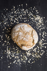 Bread with oats and seeds on a dark wooden table