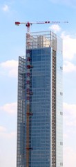 Fototapeta premium very tall skyscraper under construction made of glass and steel