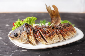 Stuffed fish with lettuce, pepper and lemon. The concept of food and restaurant.
