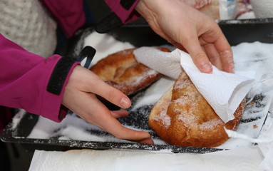 hand of the young girl puts sugar over the pancake