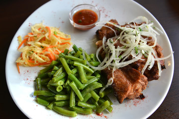 Pork shish kebab with a garnish of fresh vegetables and string bean