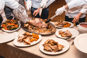 chef cuts roasted meat for restaurant guests