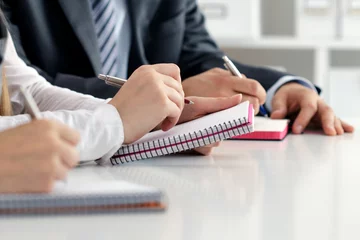 Close up view of students or businesspeople hands writing something © Liudmila Dutko