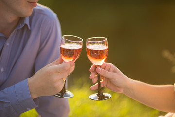 a couple in love, hands holding two glasses of wine