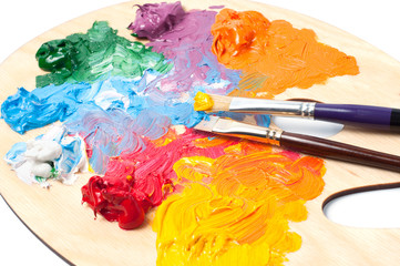 Colored artist's oil paint and brushes on the wooden palette