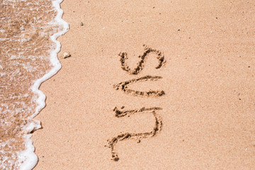 Word sun written on sand sea
