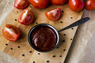 Tomato sauce with pepper. To meat and other main courses. Fresh tomatoes on a wooden board