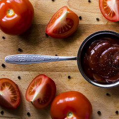 Tomato sauce with pepper. To meat and other main courses. Fresh tomatoes on a wooden board