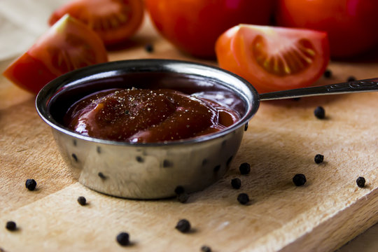 Tomato sauce with pepper. To meat and other main courses. Fresh tomatoes on a wooden board