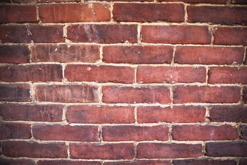 A close up of an old red brick wall