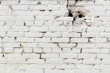 Old white brick wall with holes. Abstract background
