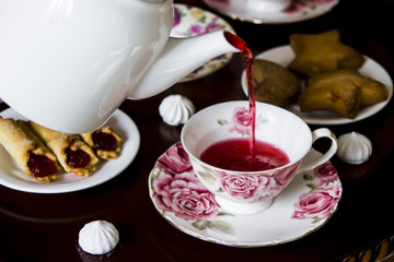 Karkade with sweets. Traditional family tea for three at a round table