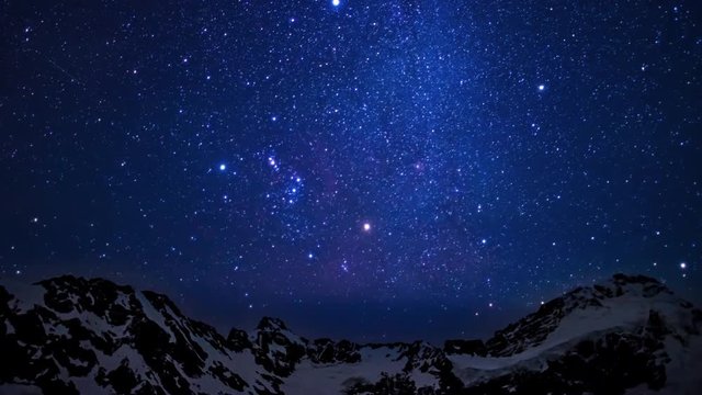 Time lapse of an amazing starry sky in motion above the summit of snowy mountains in Aoraki mount cook national park in the south island of New Zealand