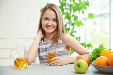 Young woman making fresh juice in the kitchen