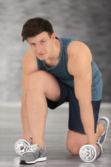 Fototapeta na wymiar Young handsome sportsman doing exercises indoors