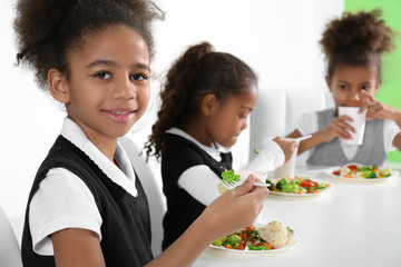 Cute African-American girls in dinning room at school