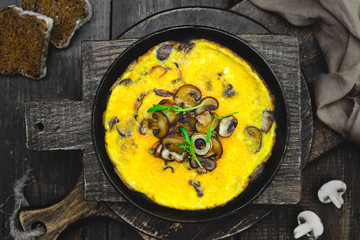 Omelette with mushrooms in a frying pan