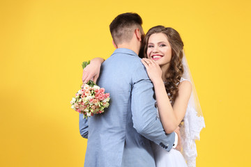 Happy wedding couple on color background