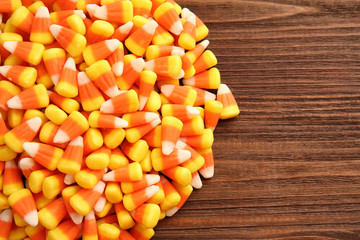 Colorful Halloween candy corns on wooden background