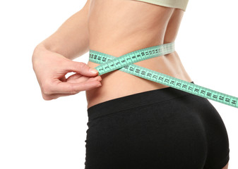Diet concept. Young woman with measuring tape on white background