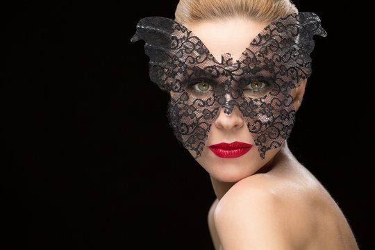 Beautiful woman in a carnival mask on black background