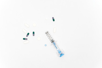 Medical syringe and pills isolated on white background