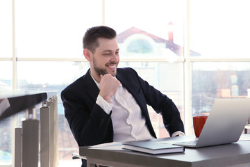 Young businessman working with laptop in office