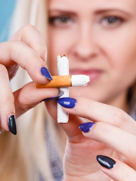 Woman breaking cigarette, getting rid of addiction