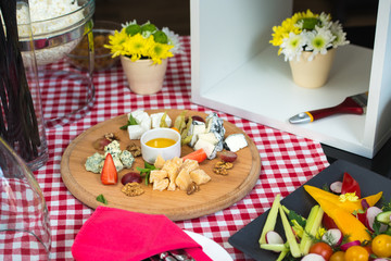 A dish with four kinds of cheese, grapes, walnuts and honey. Top view.