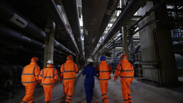  Team of engineers in power station, wide shot of workers & interior structure