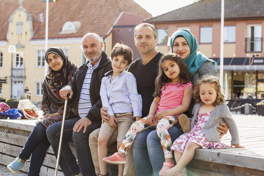 Sweden, Blekinge, Solvesborg, Portrait of family with children (2-3, 4-5, 6-7) sitting on brick wall