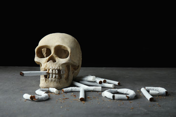 No smoking concept. Word STOP made of cigarettes and skull on grey background