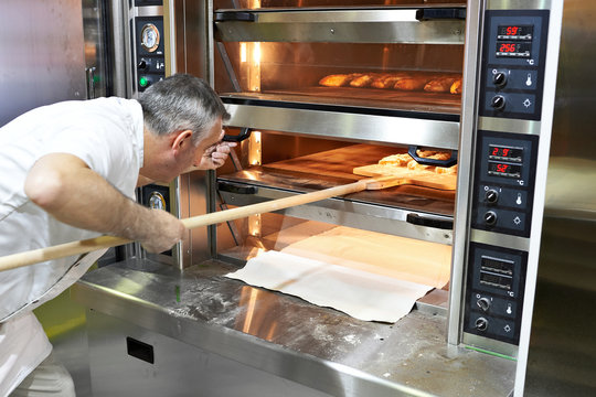 Baker bakes bread in oven