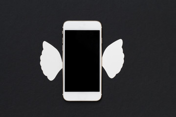 White cellphone with white angel wings on black background.