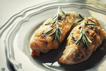 Tasty chicken breasts with rosemary on plate