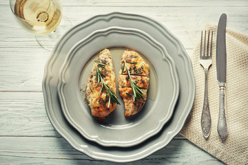 Tasty chicken breasts with rosemary on plate