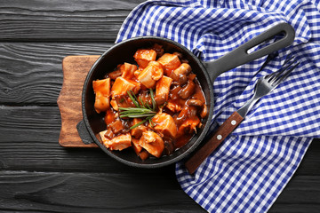 Frying pan with chicken cacciatore on kitchen table