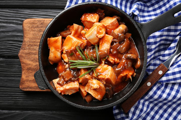 Frying pan with chicken cacciatore on kitchen table