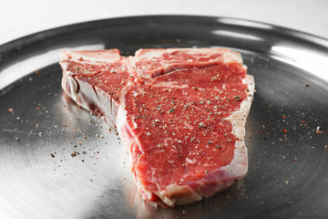 Delicious raw steak with spices on tray, closeup