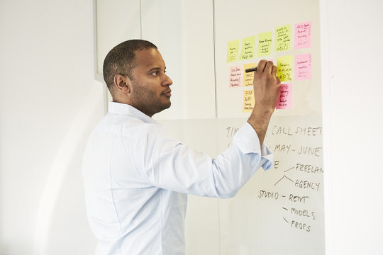 Sweden, Businessman writing on adhesive note