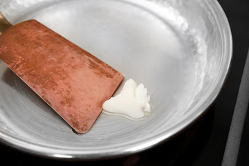 Coconut oil and spatula in frying pan