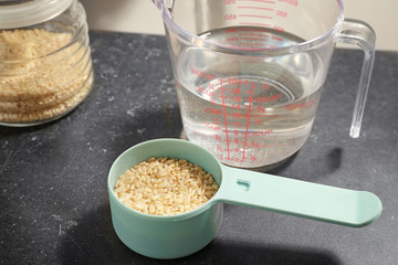 Measure scoop with brown rice on kitchen table