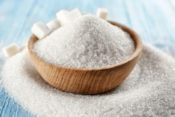 White sand and lump sugar in wooden bowl, close up