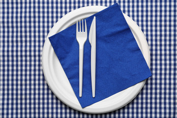 White plastic disposable tableware on napkin © Africa Studio